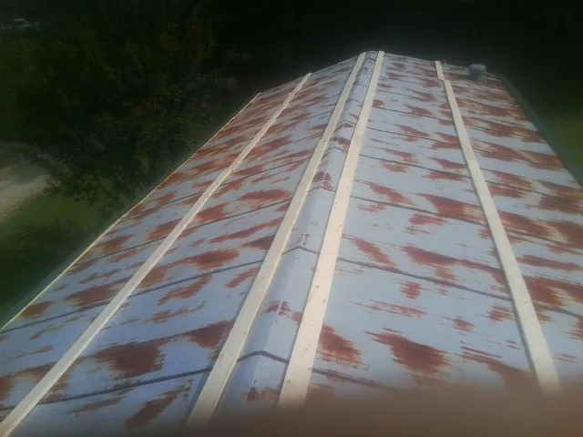 Rusted metal roof panels with new wood purlins before replacement — Storm Damage Roof Repair in Speonk by Roofing Brothers