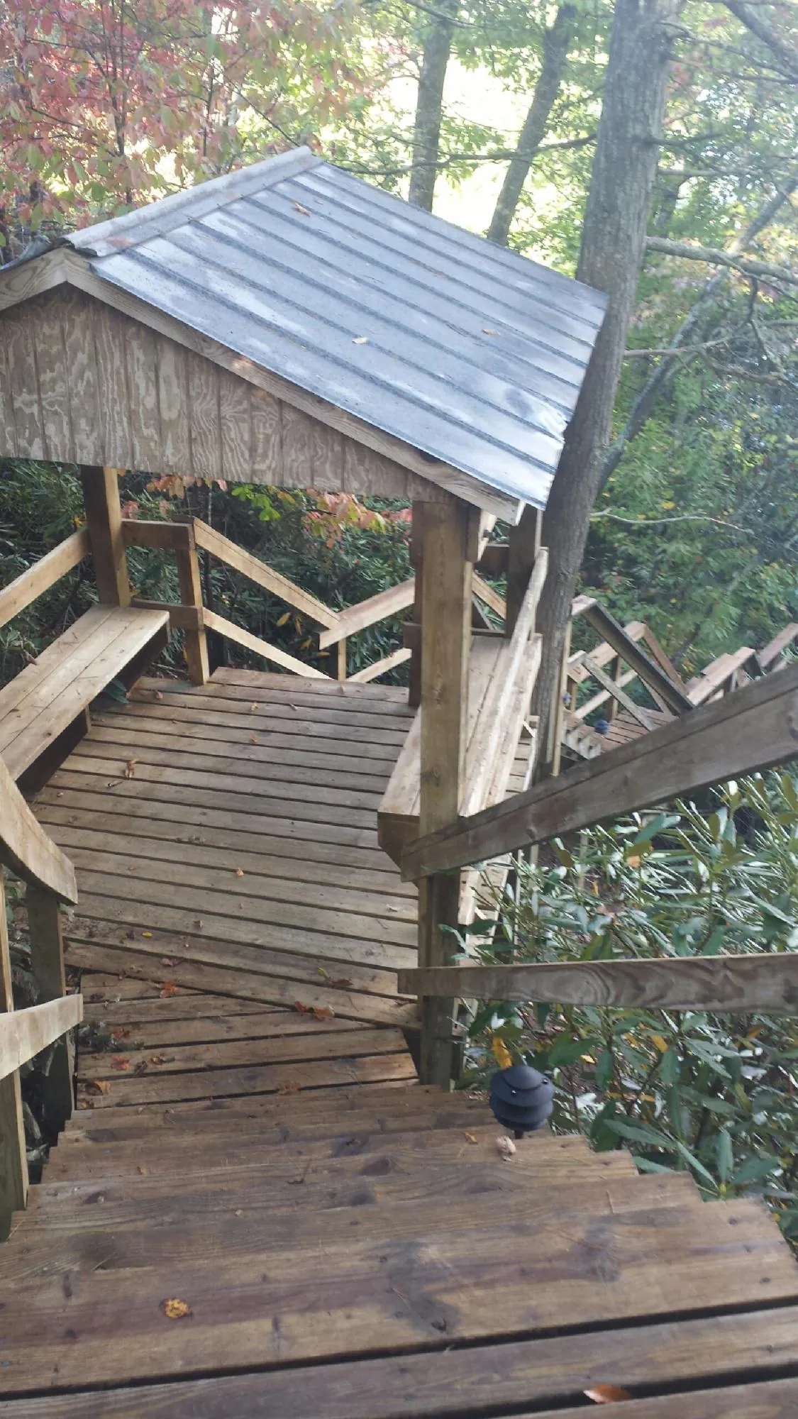 Metal roofed shelter over wooden steps on a wooded walkway — Skylight Repair & Installation work by our crew in Speonk