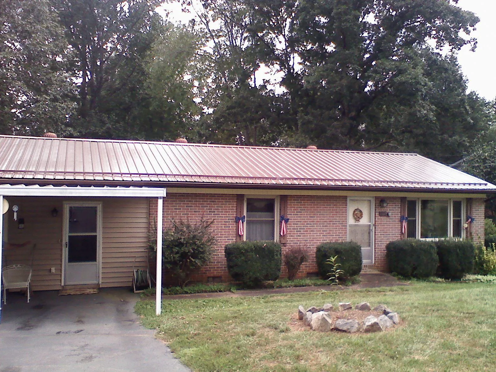Bronze metal roof and carport on a brick ranch home — Roof Repair work by our crew in Speonk